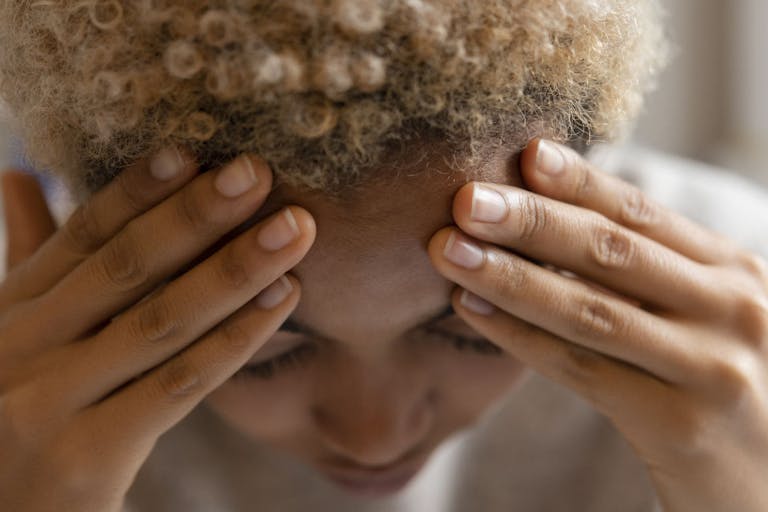 Woman with headache rubbing forehead