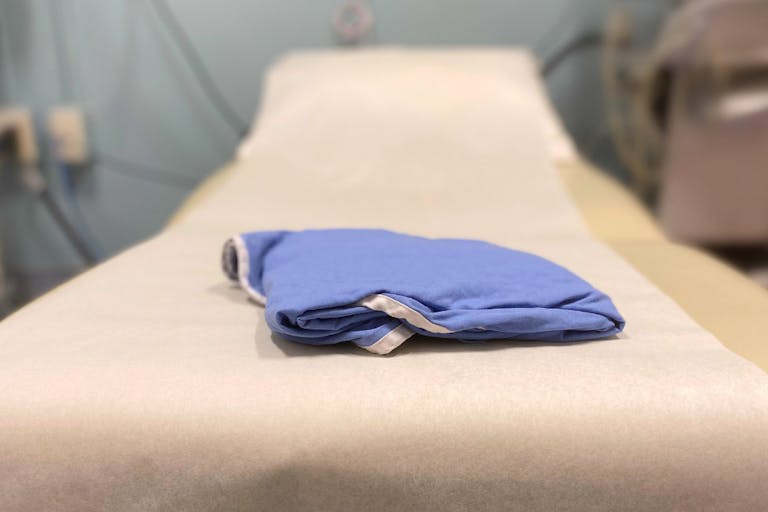 generic medical examination table & patient gown