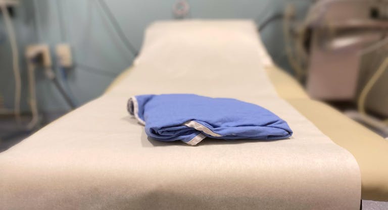 generic medical examination table & patient gown