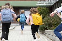 Rear view of schoolchildren running
