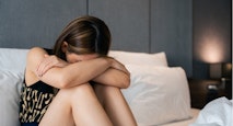 Depressed woman sitting on the bed at home