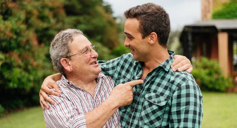 Father and adult son celebrating in their backyard