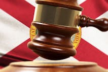 Photo: Baris-Ozer/Getty Images Wood Gavel Standing Front Of the Florida State Flag Closeup 3d Render