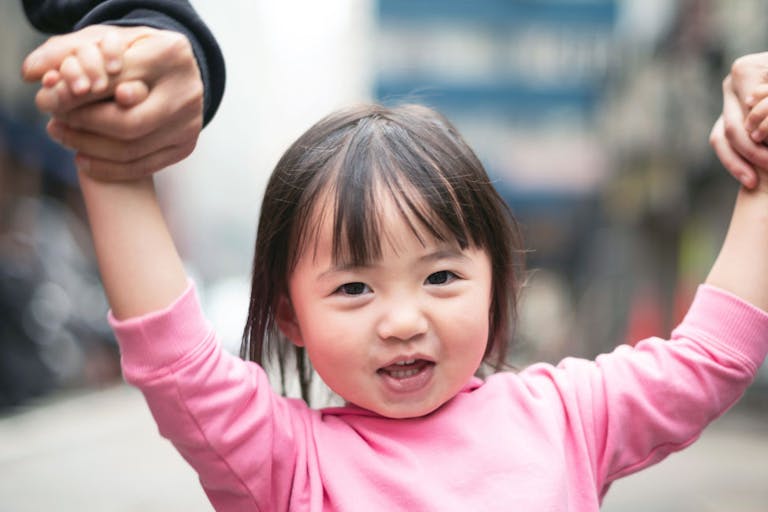 Cute little girl and parents walking on the street