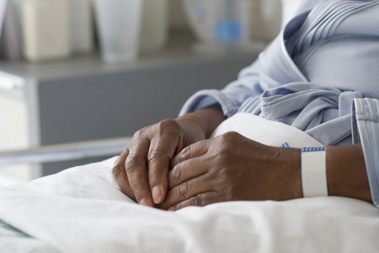 Black woman recovering in hospital bed