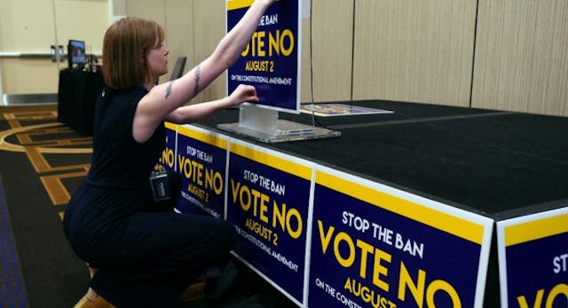 Field organizer Jae Grey places signs on the podium before the pro-choice Kansas for Constitutional Freedom primary election watch party in Overland Park, Kansas, August 2, 2022. – Voters headed to the polls in the Midwestern US state of Kansas Tuesday to weigh in on the first major ballot on abortion since the Supreme Court ended the national right to the procedure in June. (Photo by DAVE KAUP / AFP) (Photo by DAVE KAUP/AFP via Getty Images) abortion