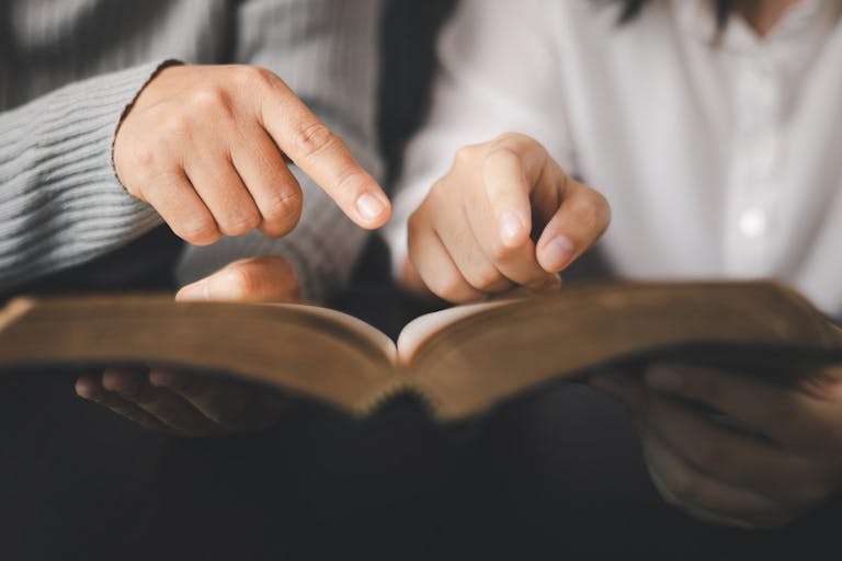 In the church, people to read Bible together, strengthening their faith as devout Catholics united by teachings of holy book. Christians are congregants join hands to pray and seek blessings of God.