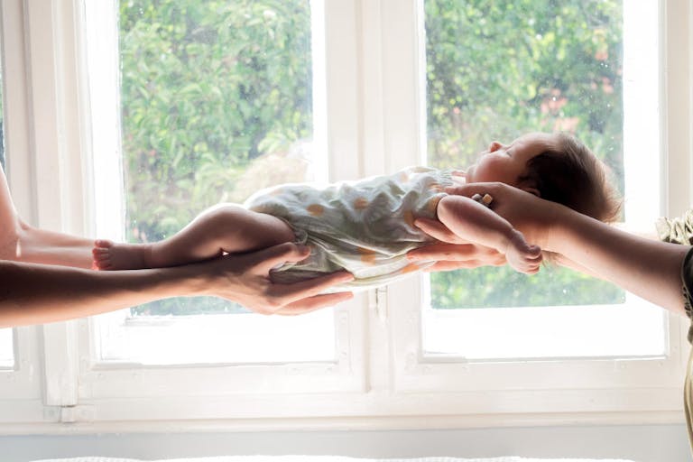 Young homosexual couple holding their new born baby