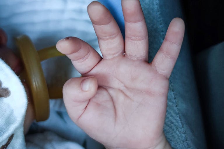 A newborn’s hand Surrogacy’s pitfalls: Heartbreaking stories of child abandonment featured image