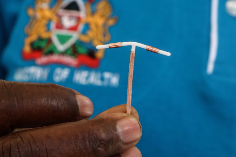 A close-up of a hand holding an Intrauterine Contraceptive