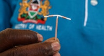 A close-up of a hand holding an Intrauterine Contraceptive