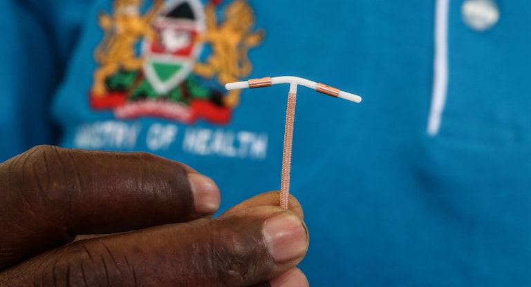 A close-up of a hand holding an Intrauterine Contraceptive