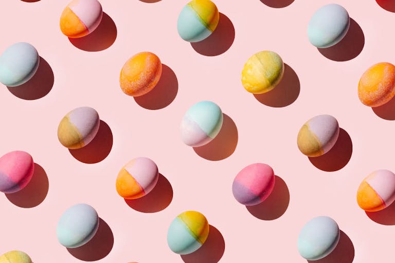 Colorful easter eggs on pastel pink background. Festive Easter pattern. Flat lay, top view