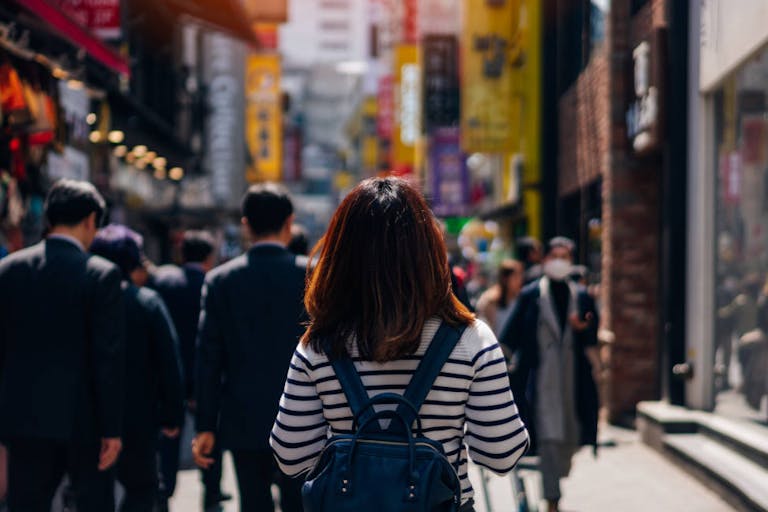 Young asian woman traveler traveling and shopping in Myeongdong street market at Seoul, South Korea. Myeong Dong district is the most popular shopping market at Seoul city.