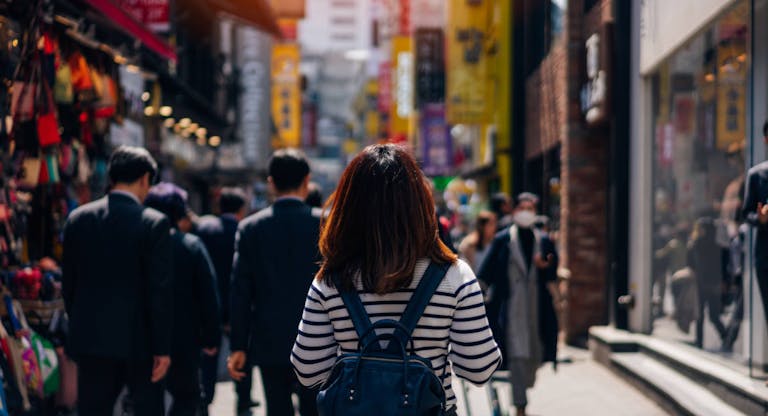 Young asian woman traveler traveling and shopping in Myeongdong street market at Seoul, South Korea. Myeong Dong district is the most popular shopping market at Seoul city.