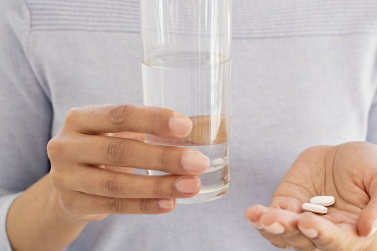 Woman holding tablets and water