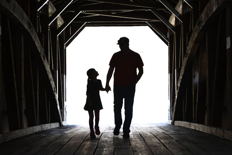 Father And Daughter On A Covered Bridge