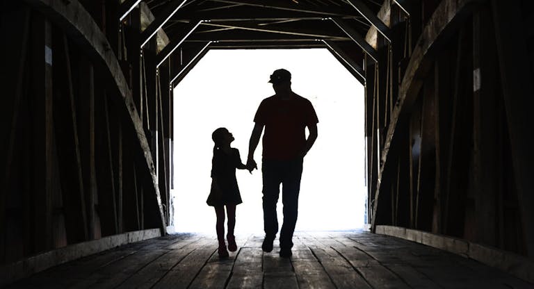 Father And Daughter On A Covered Bridge