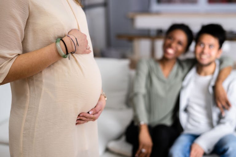 Pregnant Woman Touching Her Belly’s Woman Standing In Front