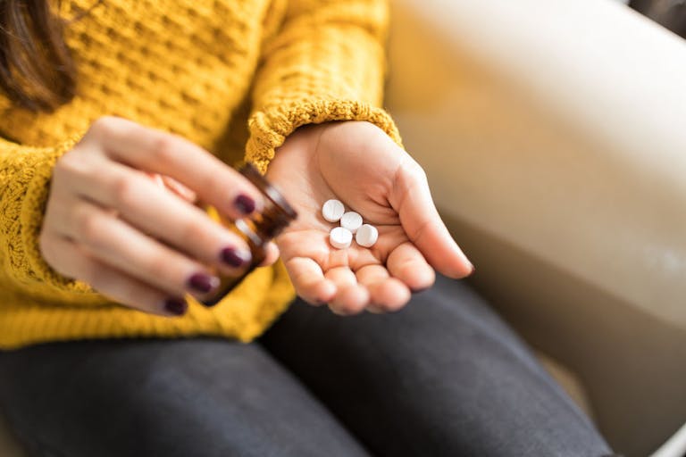 Woman Taking Out Pills From Bottle