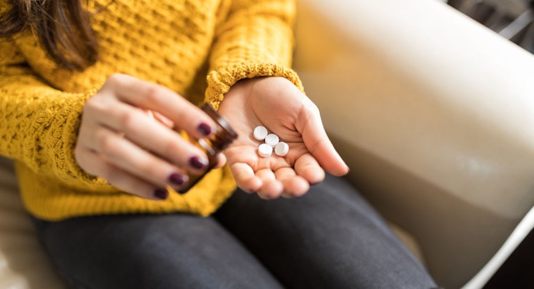 Woman Taking Out Pills From Bottle