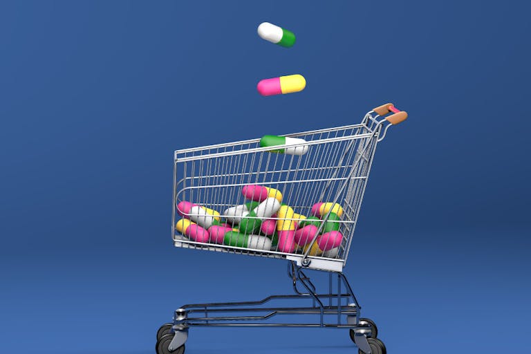 Shoping cart filled with antibiotics capsule pills. Top view. On blue background. 3D Illustration