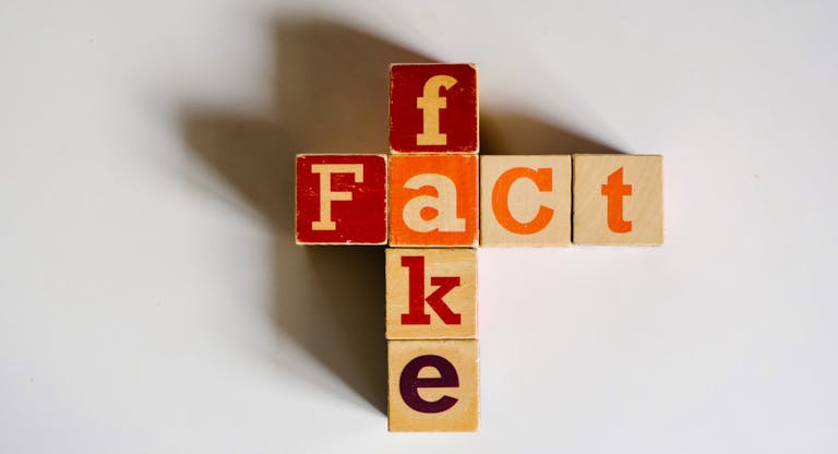 Fake  Fact Concepts with Wooden Text Alphabet Block on White Surface