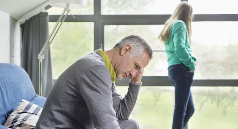 Man looking upset with his daughter standing in the background