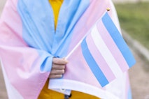 Woman covered with the transgender flag on a protest