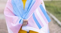 Woman covered with the transgender flag on a protest