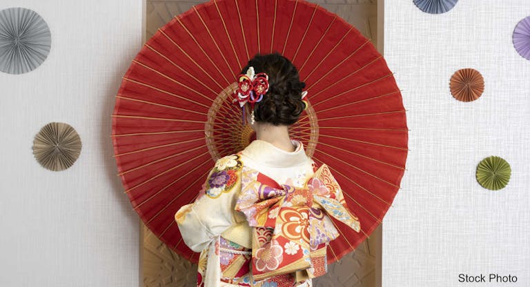 Female adult in kimono with an umbrella spread