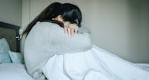 Image of woman crying with her head down. loss, abortion, Japan, miscarriage, abortion pill