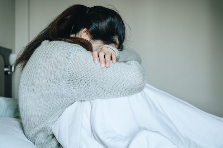 Image of woman crying with her head down. loss, abortion, Japan, miscarriage