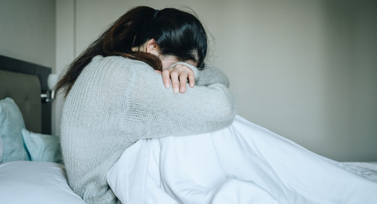 Image of woman crying with her head down. loss, abortion, Japan, miscarriage