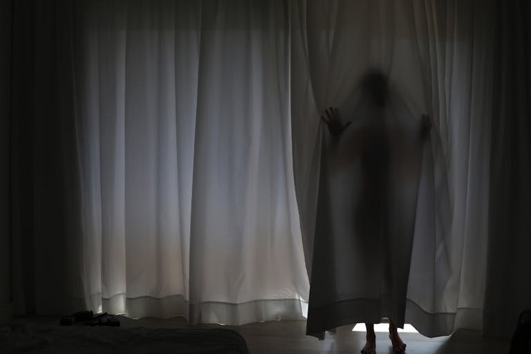 Woman behind curtain