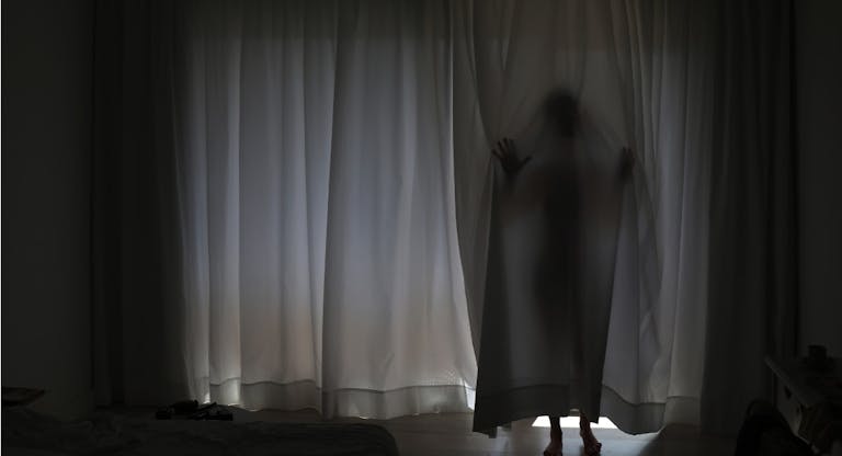 Woman behind curtain