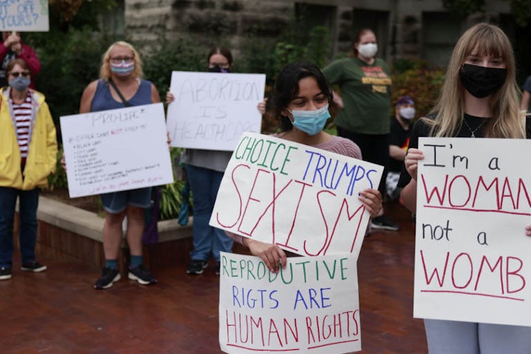 Demonstrators gather with placards expressing their opinion