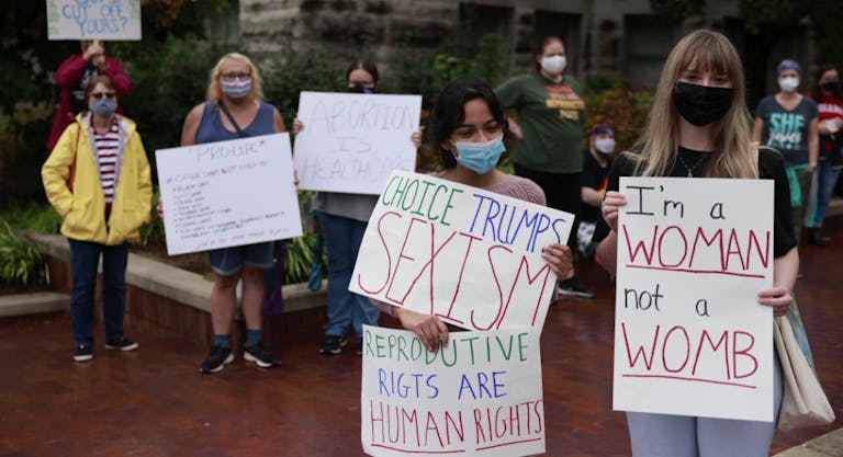 Demonstrators gather with placards expressing their opinion