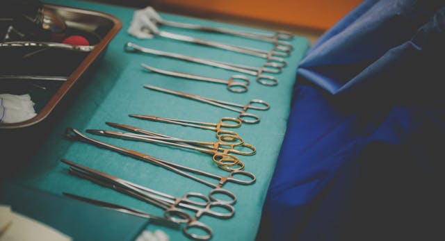 Photo: Shutterstock Dirty surgical tools laid out on a green table, abortionist