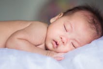 Photo: Kittikorn Nimitpara via Getty Images Asian baby sleeping on bluish white blanket