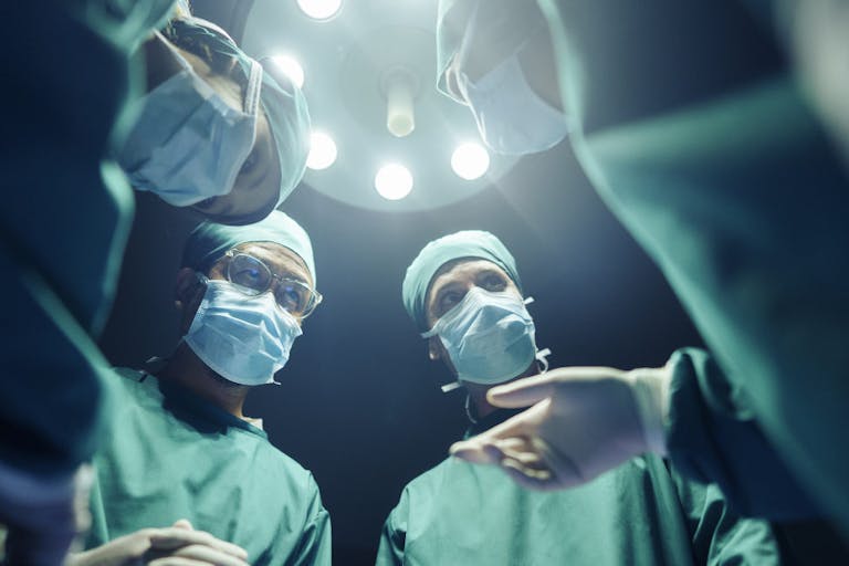 Low angle Four Surgeons coordinating their operating cases While in the operating room, teamwork and Cooperation