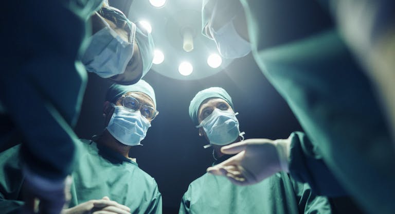 Low angle Four Surgeons coordinating their operating cases While in the operating room, teamwork and Cooperation