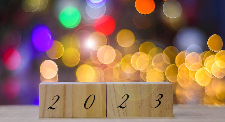 The number 2023 on wooden blocks against illuminated defocused bokeh lights – New year concept