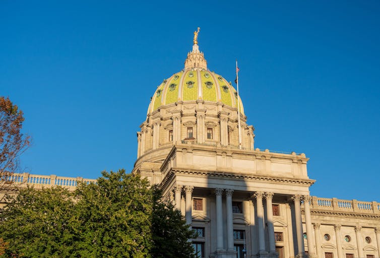 Setting sun shines on the ornate dome of Pennyslvania State Capitol