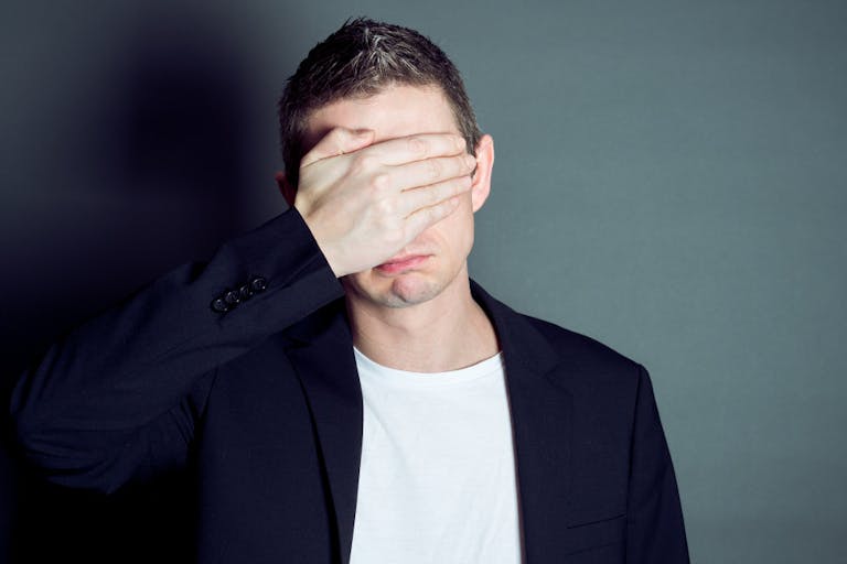 Young male cover his eyes
