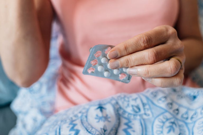 Close-up of woman hands with pills. Hormone replacement therapy