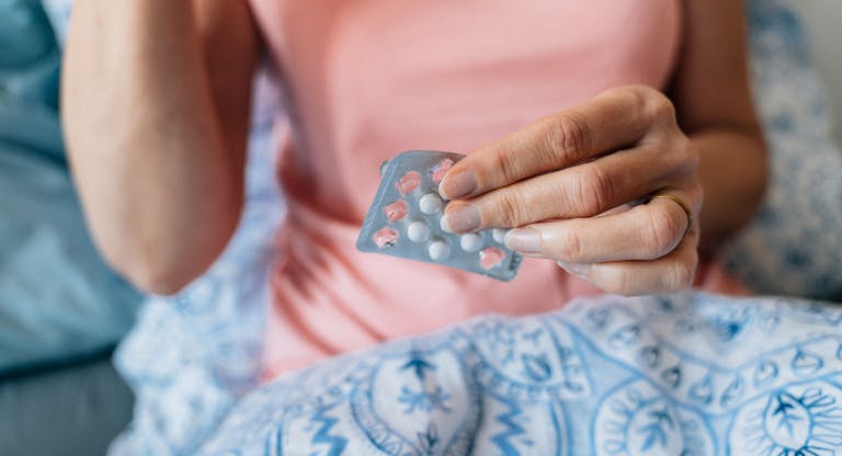Close-up of woman hands with pills. Hormone replacement therapy