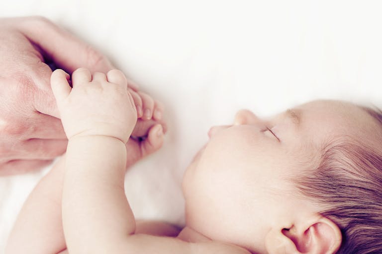 white-baby-finger-holding-hand