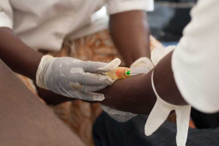 African nurse draw blood from African male