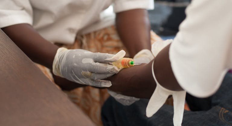 African nurse draw blood from African male